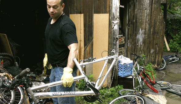 Det. Izzy Bernardo with the Major Crimes Unit, 14 division takes a bike from a Parkdale garage from a stash of recovered stolen bikes