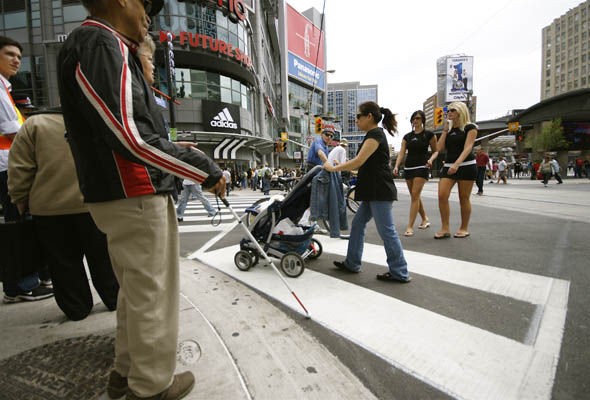 Davis McCarroll, 91, gets ready to cross the new scramble pedestrian crossing at Yonge and Dundas in Toronto